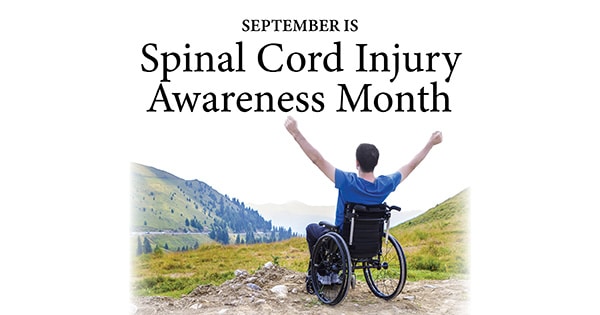 man in a wheelchair with arms in the air celebrating spinal cord injury awareness month