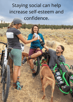 a group of ostomates staying social with an ostomy cheers-ing while out on a hike with their dogs and bikes