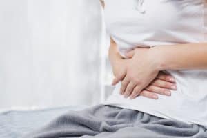 woman holding her stomach in discomfort