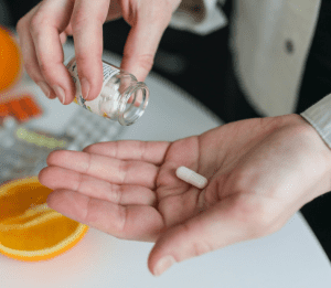 person pouring pills from a prescription bottle into their hand
