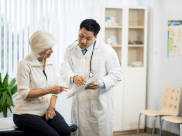 older female patient going over her irritable bowel syndrome lab results with Asian doctor