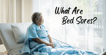 Asian woman sitting upright in a hospital bed trying to prevent bed sores from occurring