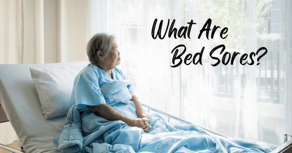 Asian woman sitting upright in a hospital bed trying to prevent bed sores from occurring
